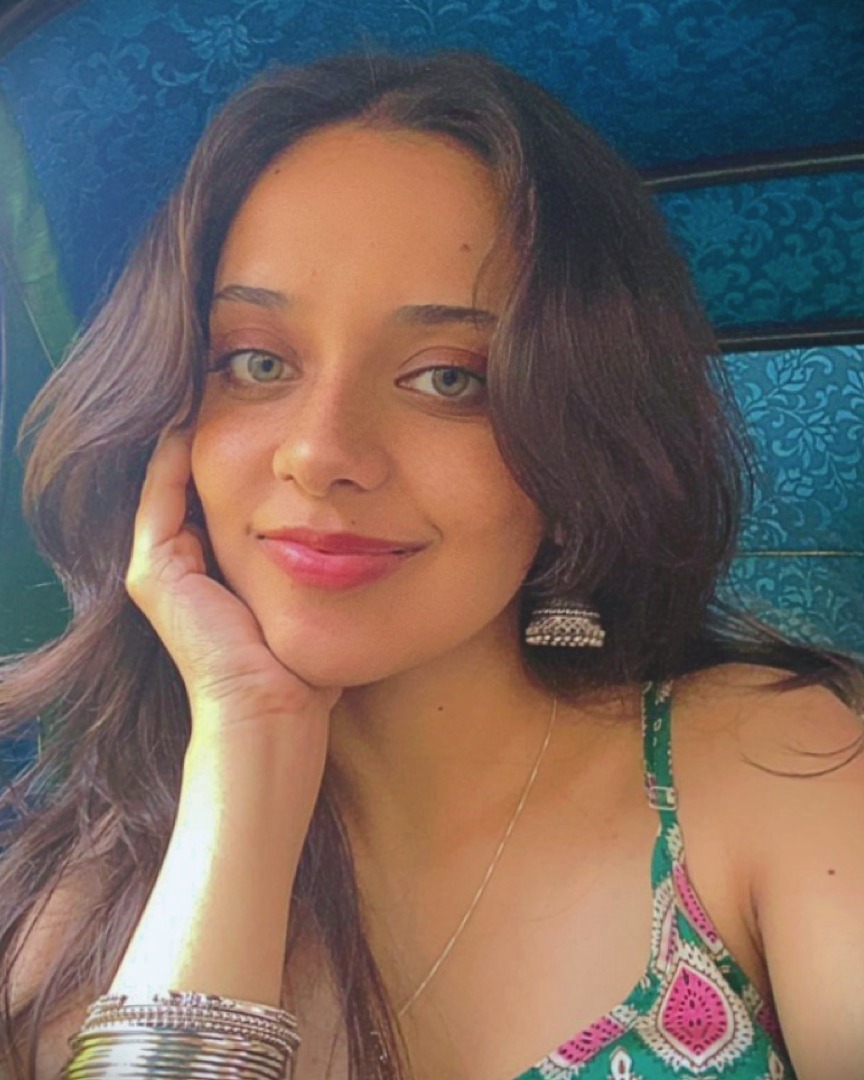Isha smiling, chin resting on her hand